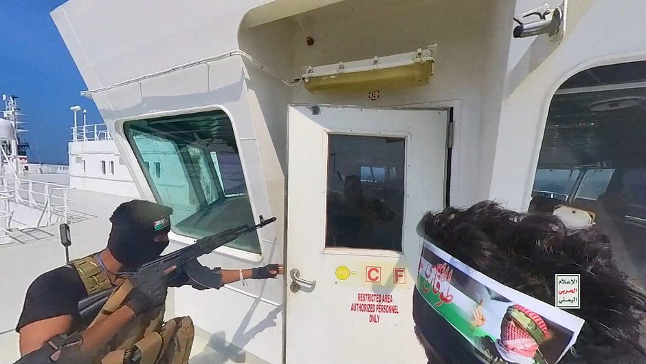 Боевики-хуситы открывают дверь кабины на палубе корабля в Красном море, 20 ноября 2023 года